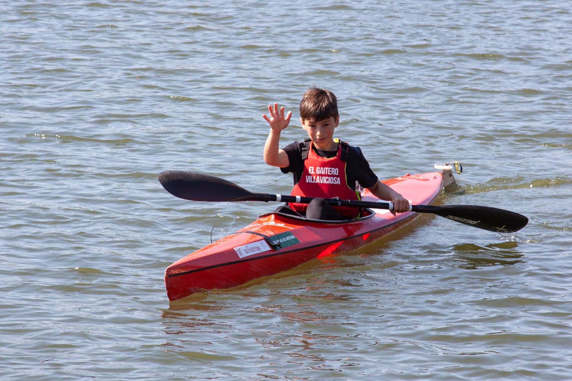 Mateo de niño saludando desde el kayak